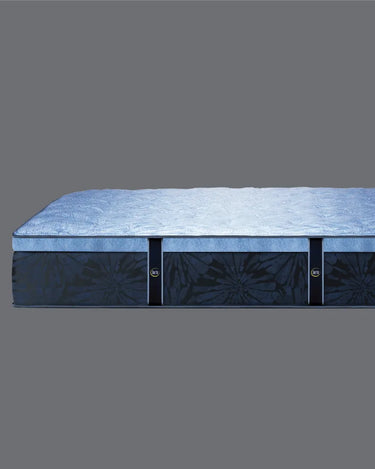 Side profile view of Serta Classic Latex mattress showing soft blue plush pillow-top surface and deep navy blue floral tie-dye patterned base border on a grey background