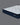 Angled view of Serta Classic Luxury mattress displaying white quilted bubble-tufted top and navy blue tie-dye floral-pattern border on a grey background