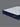 Angled view of Serta Classic Luxury mattress displaying white quilted bubble-tufted top and navy blue tie-dye floral-pattern border on a grey background