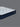 Low side-angle view of Serta Classic Luxury mattress highlighting the white tufted sleep surface and bold navy blue tie-dye floral side border with brand label