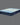 Angled view of Serta Classic Plus mattress displaying light blue tufted sleep surface and deep navy blue floral-pattern side border on a grey background