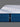Close-up corner view of the Serta iLatex mattress highlighting the wave-quilted navy blue border with a Serta logo badge and thick pillow top