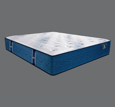 Full angled view of the Serta iLatex mattress displaying its plush white tufted top and navy blue quilted sides with wave stitch detailing