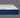 Side profile view of the Serta iLatex mattress showcasing its thick white tufted pillow top and deep navy blue wave-patterned quilted border