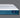 Side profile view of the Serta iPedic mattress showcasing its white striped top and deep blue quilted border on a grey background