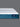 Side profile view of the Serta iPedic mattress showcasing its white striped top and deep blue quilted border on a grey background