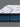 Corner close-up of Serta Perfect Sleeper mattress highlighting the white dash-patterned pillow-top layer and medium blue oval chain-stitched border with Serta brand label