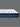 Side profile view of Serta Perfect Sleeper mattress showing white dash-pattern quilted pillow-top surface and medium blue oval chain-patterned base border on a grey background