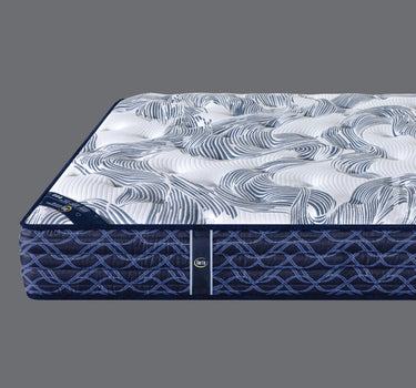 Close-up angled view of Serta PerfectSpine mattress showcasing tufted wave-pattern top surface and navy blue geometric border design